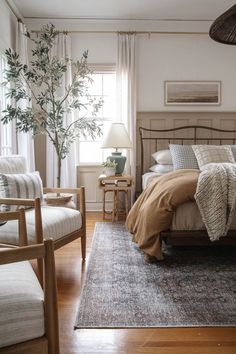 a bedroom with a bed, two chairs and a rug