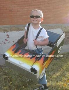 a little boy in a costume that is made to look like a box with flames on it