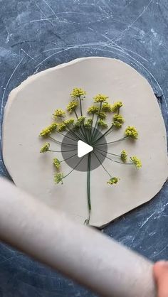 someone is making a flower sculpture out of clay