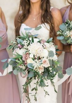 the bridesmaids are holding their bouquets with greenery and flowers on them