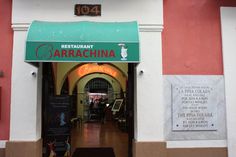 an entrance to a restaurant with signage on the wall and in front of it is a sign that says cafe carracina