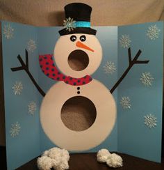 a snowman made out of toilet paper on top of a wooden table in front of a blue wall