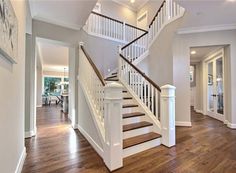 a white staircase with wooden handrails in a home's entryway area