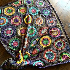 a crocheted blanket is laying on the floor