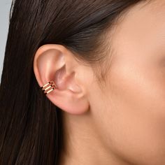 a close up of a woman's ear with two small gold rings on it