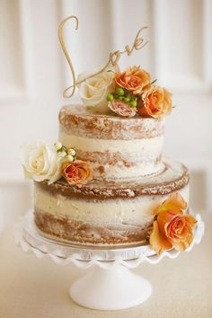 a three tiered wedding cake with flowers on the top and love written on it