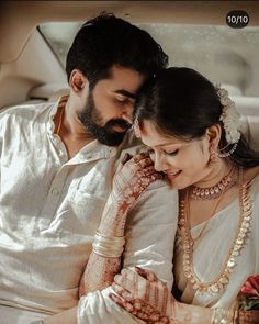 a bride and groom sitting in the back of a car