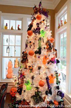 a white christmas tree decorated with halloween decorations