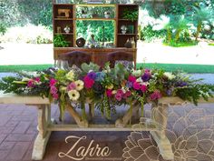 a wooden table topped with lots of flowers