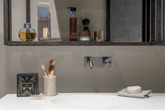 a bathroom sink with soap, toothbrushes and other personal care items