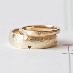 two gold wedding bands with hearts on them