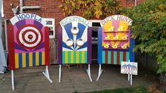 three brightly colored booths sitting in front of a brick building