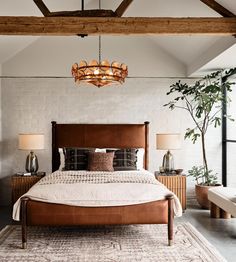 a large bed sitting under a wooden beam in a bedroom next to two tables with lamps on them