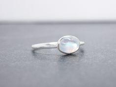 Solid .925 sterling silver ring with horizontally set 8x6mm genuine rainbow moonstone. Stackable ring. The ring is solid sterling silver so it is very durable.  Also available in 14k gold filled and rose gold filled. https://www.etsy.com/shop/LyndyLouDesigns?ref=listing-shop-header-item-count&search_query=rose+gold+gemstone+rings This ring is made to order in your size. If you don't see your size available please feel free to message me. Gemstone information: Gemstone Type:Rainbow Moonstone  Exa White Oval Moonstone Ring In Minimalist Style, Minimalist Oval Moonstone Birthstone Ring, Dainty Silver Oval Moonstone Ring, Minimalist Silver Oval Opal Ring, Minimalist Oval Moonstone Ring, Minimalist Moonstone Opal Ring In Silver, Adjustable Silver Moonstone Ring In Oval Cabochon, Silver Moonstone Multi-stone Rings, Minimalist Sterling Silver Cabochon Moonstone Ring