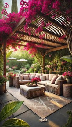 an outdoor living area with couches, tables and pink flowers on the arbors