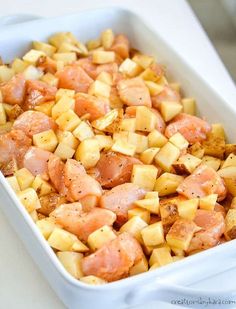 a white dish filled with potatoes and ham