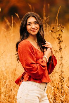 a beautiful young woman standing in tall grass