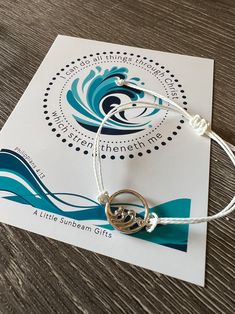 a bracelet with two silver rings on it sitting on top of a piece of paper