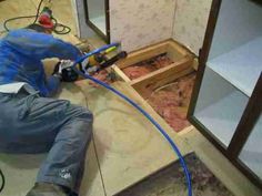 a man laying on the floor with a power drill