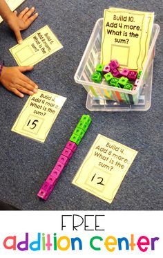 a table topped with lots of different types of letters and numbers on paper next to a plastic container filled with magnets