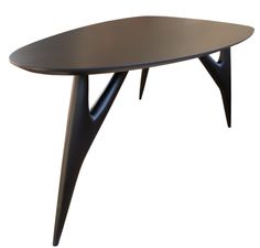 an oval table with black legs and a wooden top