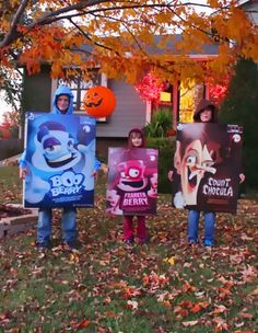 three children holding posters in front of a house with pumpkins on the ground and trees