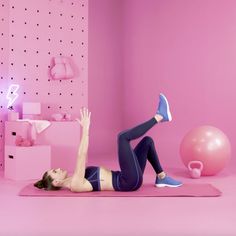 a woman is doing exercises on a yoga mat in a room with pink walls and polka dots