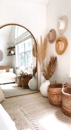 an image of a living room with mirrors and baskets on the floor in front of it