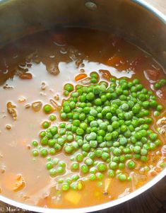 peas are being cooked in a saucepan on the stove top, ready to be eaten