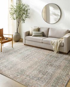 a living room with a couch, chair and mirror on the wall next to a potted plant