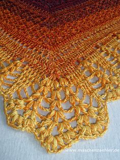 an orange and yellow crocheted table cloth