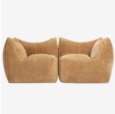 a pair of brown chairs sitting next to each other on top of a white background