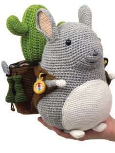 a crocheted stuffed animal with a cactus in it's mouth and a handbag