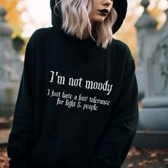 Gothic Hoodie with a funny Goth Quote on the front: I'm not moody, I just have a low tolerance for light & people. This black Spooky Hoodie creates a dark gothic and witchy style. Fun for a Halloween lover or a sarcastic person. ❗️❗️❗️Please be aware that the  Hoodie is an Unisex Cut and may be oversized.  Please check the size charts to measure yourself to be sure you will receive a good sized item. 🖤 The position, colors and size of the print may differ slightly from the illustrations. SHIPPI Winter Emo Sweatshirt With Letter Print, Alternative Style Halloween Hoodie With Letter Print, Alternative Halloween Hoodie With Letter Print, Emo Letter Print Sweatshirt For Fall, Hooded Hoodie With Letter Print For Alternative Fashion, Alternative Hoodie With Letter Print For Fall, Fall Hoodie With Letter Print For Alternative Fashion, Alternative Letter Print Hoodie For Fall, Witchy Clothes Aesthetic