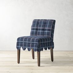 an upholstered chair with scalloped legs and a blue checkered fabric