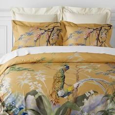 the comforter is made up with an image of a bird and flowers on it