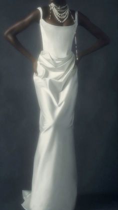 a woman in a white dress with pearls on her neck