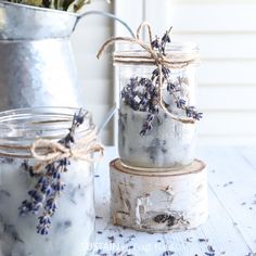 three jars filled with lavender flowers sitting on top of a table