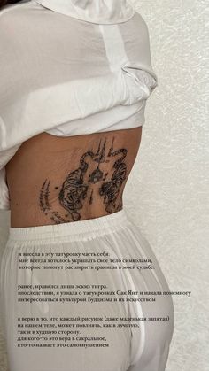 the back of a woman's stomach with tattoos on her lower body and side