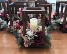 a candle in a wooden box with flowers around it