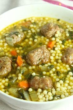 a white bowl filled with soup and meatballs