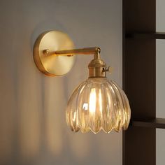 a light that is on the wall next to a lamp shade and some bookshelves