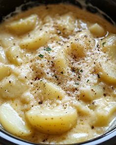 a bowl filled with macaroni and cheese covered in parmesan cheese sauce