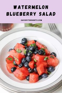 watermelon and blueberry salad on a white plate with silverware in the background