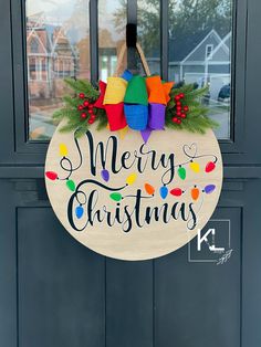 a merry christmas door hanger on the side of a front door with holiday decorations