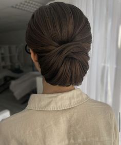 the back of a woman's head, with her hair in a low bun