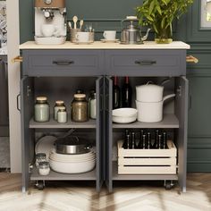 a kitchen island with pots and pans on it in front of a green wall