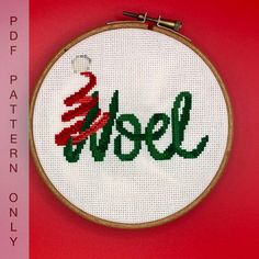 a cross stitch christmas ornament with the word noel written in red and green