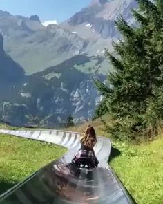 a woman riding on the back of a slide down a hill