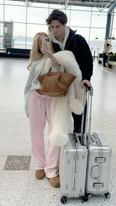 a man and woman standing next to each other with luggage